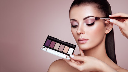 Wall Mural - makeup artist applies eye shadow. beautiful woman face. perfect makeup. make-up detail. beauty girl 