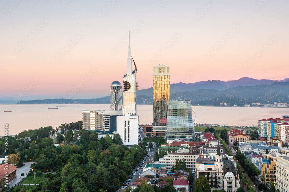 Batumi, Adjara, Georgia - October 2018: Panoramic view of Batumi sea resort from the Sheraton hotel at the sunset with skyscrapers and mountains in background
