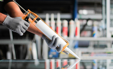 Men's hand uses silicone adhesive with adhesive to connect the mirror with aluminum.