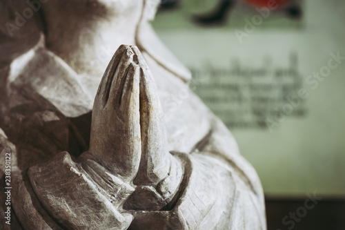 Fotografie, Obraz Close up sur des mains en prière, statuette religieuse