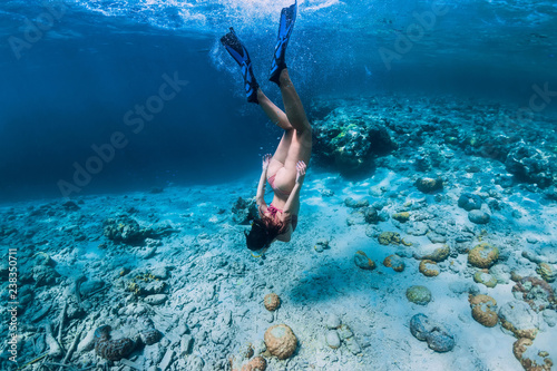 Fotografía Woman free diver in bikini swim to deep in the tropical blue ocean