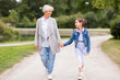 © Syda Productions - family, leisure and people concept - happy grandmother and granddaughter walking at summer park