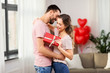 © Syda Productions - valentines day, relationships and people concept - happy couple with gift box hugging at home