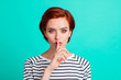 Close-up portrait of nice attractive sweet lovely red-haired lady in striped pullover showing hush sign symbol isolated over bright vivid shine green turquoise background