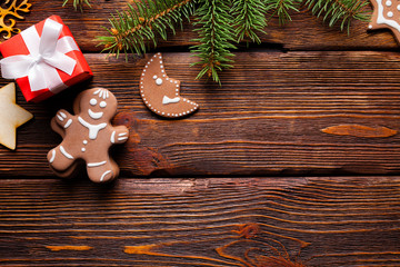 Poster - Christmas background - gingerbread cookies, red gift box and spruce tree on wooden background