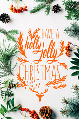 Wall Mural - flat lay with winter arrangement of pine tree branches, cones and sea buckthorn on white backdrop wi