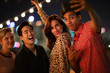 © ReeldealHD images - Group of friends taking selfie at an outdoor party at night