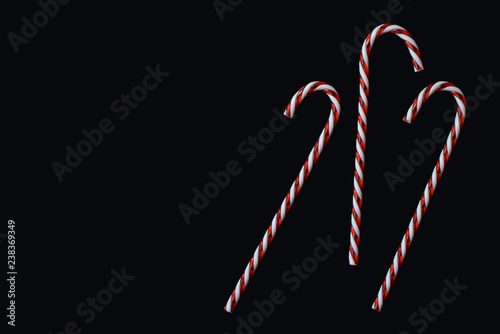 Fotografía Red and white traditional Christmas candy cane on black background greeting card