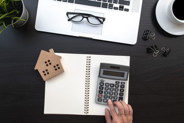 Fototapete - Flat lay of top view modern black wood desk work table with computer laptop and home property analysis office includes copyspace for add text or graphic