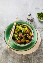 Wall Mural - Basmati rice with tofu in General Tso sauce and steamed broccoli. full healthy vegetarian lunch or dinner on a stone table