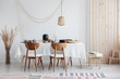 Bright and white dining room with wooden furniture and natural materials