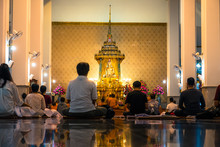 Night Scene Of People Meditating In The Temple. Wat Pathum Wanaram Temple, Bangkok, Thailand.
