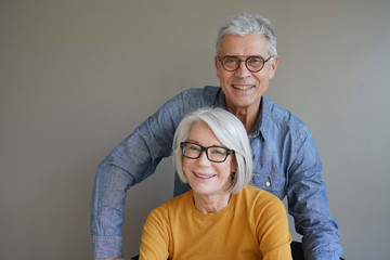 Wall Mural -  Portrait of relaxed fun senior couple wearing glasses on background