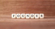 Word FOUNDER made with wood building blocks