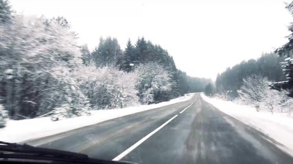 Wall Mural -  driving by car along a winter snowy forest road.