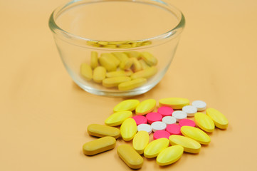 Assorted pharmaceutical medicine pills, tablets and capsules on glass bowl