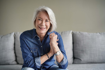 Wall Mural -  Portrait of modern senior woman laughing in all denim on couch