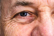 Close up of a smiling older man's eye.