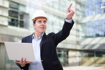 Smiling man in helmet working at the laptop