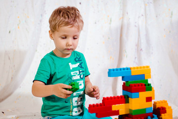 Wall Mural - small child learns to fold constructor