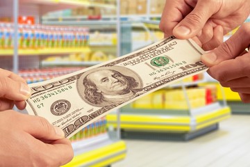 Hands holding one hundred dollars banknote over background