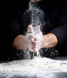 man's hands and splash of white wheat flour