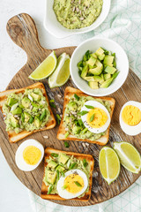 Wall Mural - avocado toasts, healthy snack of grilled bread with guacamole slices avocado, boiled eggs, chia seeds and green onions