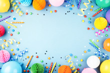 Birthday Party Background On Blue. Top View. Frame Made Of Colorful Serpentine, Balloons, Candles, Candies And Confetti.