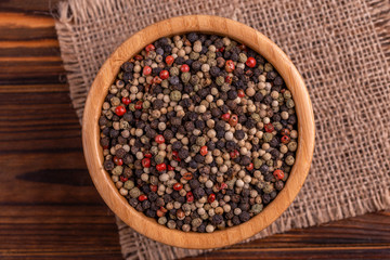 Wall Mural - Mix of peppers in bowl burlap napkin on wooden background