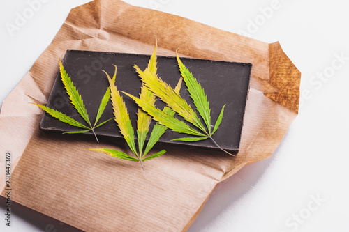 Fotografie, Obraz Marijuana leaf with edible dark chocolate block and cannabis brownie with ganja