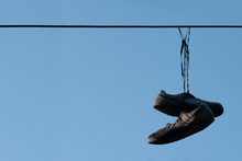 Shoes Hanging On Wire With Blue Shy Background