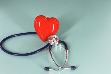 Red heart and a stethoscope on desk