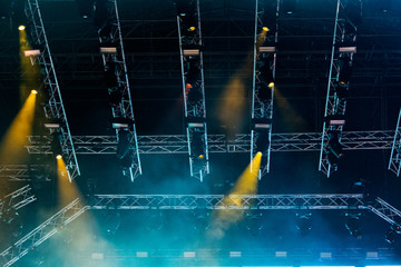 Concert lights, stage, show and excitement.  Light spots in concert, outdoor stage at night, foggy electricity.