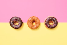 Overhead view of donuts arranged on colored background