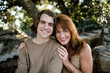 © Cavan Images - Portrait of smiling mother with son sitting in park