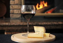 Close Up Of Wine With Cheese Slices Served On Wooden Tray