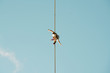 © Cavan Images - Low angle view of man slacklining against clear blue sky during sunny day