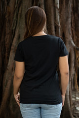 Woman wearing black t shirt in back side view in outside, ready for your mock up design template or presentation your design project