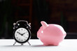 Alarm clock and piggy bank concept for saving time