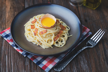 Spaghetti Carbonara ,Homemade traditional Italian pasta with parmesan cheese, eggs and pancetta or bacon on dark rustic wooden table