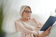 © goodluz - Beautiful senior woman relaxing in bed reading
