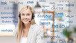© Syda Productions - translation, business and technology concept - smiling female translator or operator in headset at office over greeting words in different foreign languages