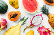 © SEE D JAN - Flat lay tropical fruit layout made of dragon fruit, watermelon, papaya and pineapple on a white background, creative summer food concept