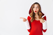 Image Of Beautiful Woman 20s Wearing Christmas Red Dress Pointing Fingers At Copyspace While Standing, Isolated Over White Background