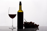 Fototapeta  - Red wine bottle, wineglass, and grapes, isolated on white.