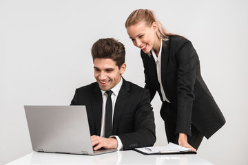 Wall Mural - Smiling business couple wearing suits isolated