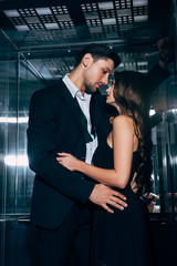 beautiful romantic couple passionately looking at each other and embracing in elevator