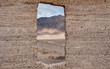 Looking out at mountain range through abandoned building in Death Valley national park