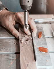 Wall Mural - Drill a mill for a tree in the boring machine with a laser marking. Hands master drills a hole in a wooden bar.