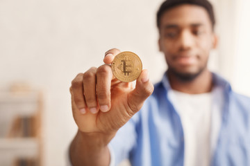 Poster - Golden bitcoin in african-american man hand closeup